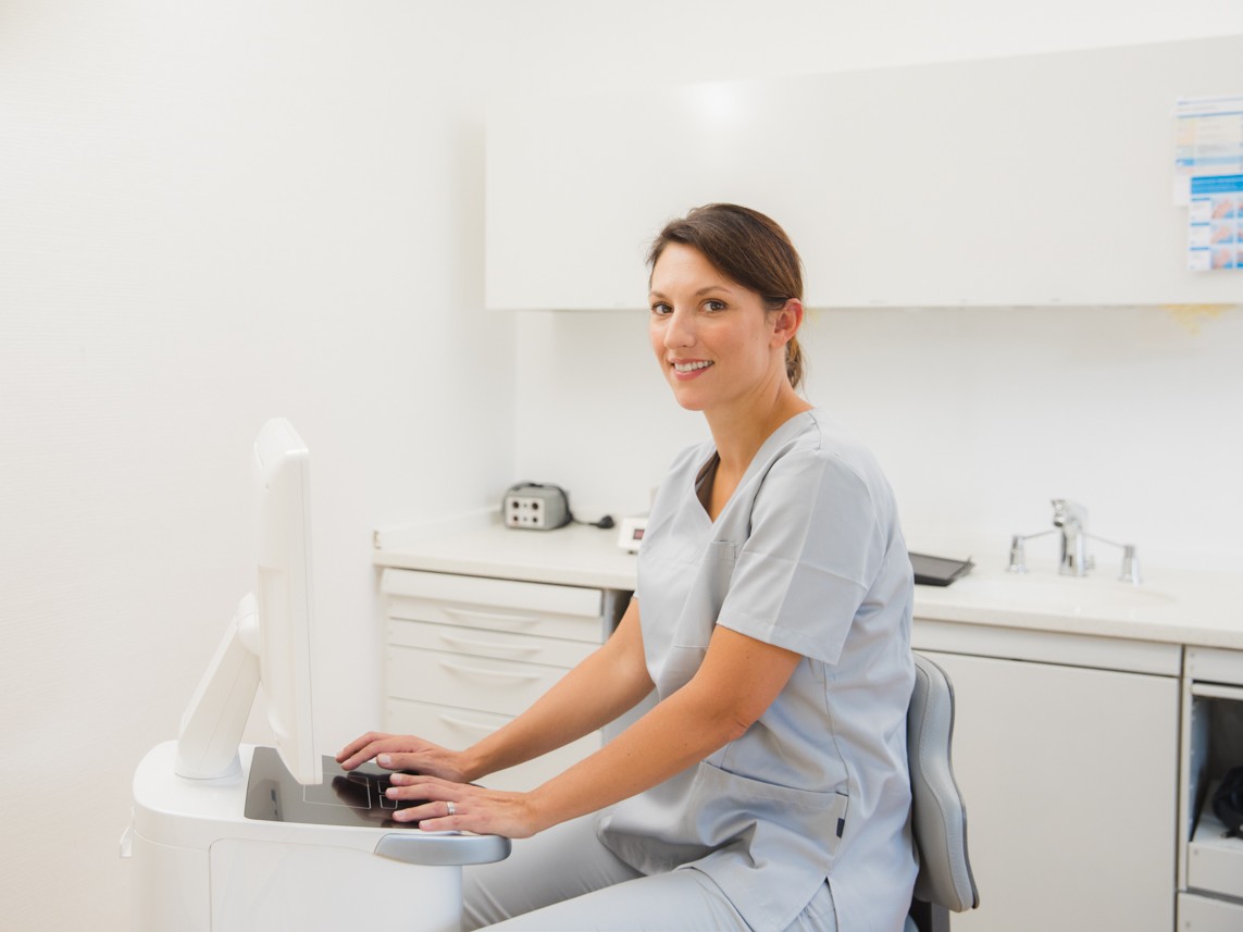 Praxisteam an einer CEREC-Aufnahmeeinheit mit Monitor